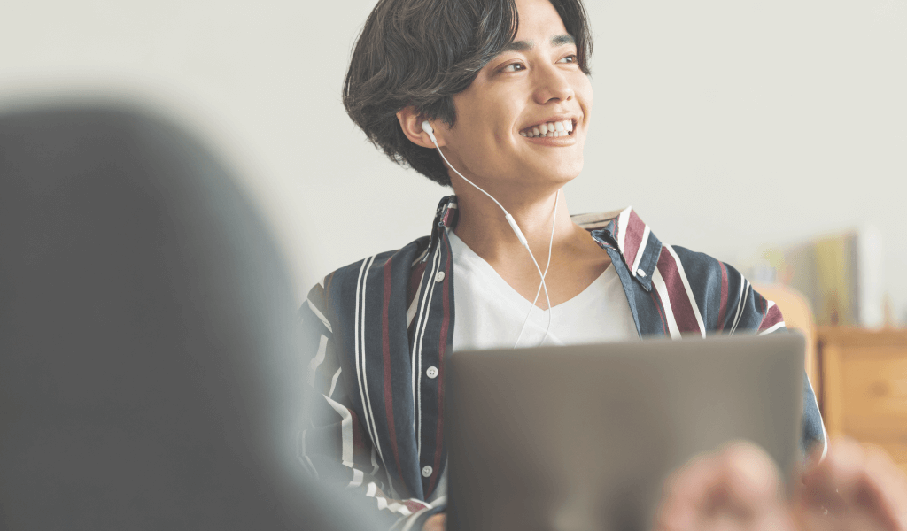 在宅勤務をしながら音楽を聴く男性の写真